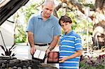 Father and son changing the air filter in the family car.