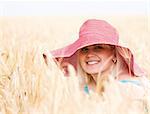 Beautiful woman with hat in wheat meadow on sunny day