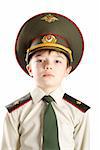 Close-up portrait of young boy in Ministry of Defense cap and military uniform. Image isolated on pure white background