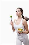 Beautiful girl running with a salad on a white background