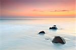 Sunrise over the sea. Stone on the foreground