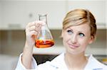 Portrait of a concentrated female scientist looking at an erlenmeyer in her laboratory