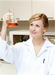 Portrait of a bright female scientist looking at an erlenmeyer in her lab