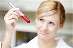 Close-up of a female scientist looking at a test tube in her lab