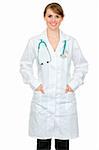Smiling medical doctor woman holding hands in pockets of robe isolated on white