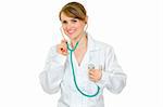 Smiling  doctor woman listening to her heart with stethoscope isolated on white