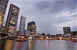 Skyscrapers in the colorful sunset harbor in Singapore, asia.