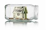 Savings and investment - Money house and coins in glass jar on white background