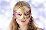Young beautiful woman in violet dress wearing carnival mask