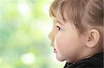 Portrait of a 2 year old girl against abstract green background