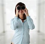 Young caucasian business woman looking throught binocular