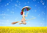Red-haired girl fly with umbrella over rape field and bubbles around.