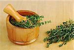 Fresh thyme with wooden mortar and pestle on wooden board (Selective Focus)