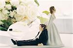 Closeup of whimsical wedding cake figurines on white