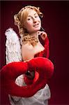 Perfect blonde angel with a red heart at red background