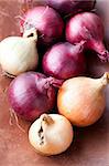 Close-up of red and yellow onions on a wooden background