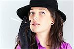 Portrait of a beautiful brunette young woman with black hat and cigar