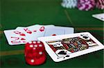 green casino table with dice and a hand of a royal flush in a poker game and the jack of spades in the pack