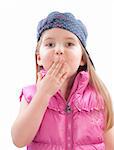 little girl covers mouth with hand on white