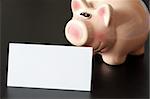 piggy bank and blank sheet of paper with copyspace for text message