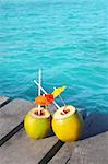 coconut coktails in caribbean on wood pier turquoise sea