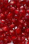 Macro up view of peeled red ripe pomegranate seeds.