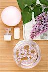 On the wooden table flowers, cream, soap, a brush for cleaning person