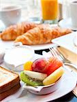 Breakfast with coffee and croissants in a basket on table