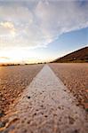 landscape in nature and countryroad adventure with beautiful sunset and dramatic clouds and sky