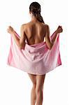 young brunette showing her back shoulder and covering her naked body with a pink towel