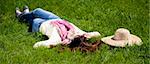 Brunette girl with headphone lies in the park.