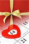 Composite image of gold bow ribbon on calendar page showing Febraury 14 Valentine's day