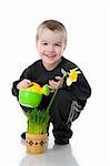 Cute little boy watering the flower. Studio shot