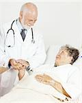 Friendly doctor comforting a senior hospital patient.