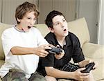 Competitive brothers playing video games at home.