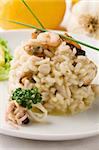 photo of delicious risotto with seafood on white isolated background