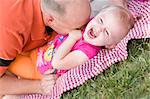 Loving Dad Tickles His Daughter in the Park.