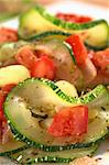 Sauteed zucchini slices, tomato cubes, onion and cooked corn grains with dried herbs and black pepper (Selective Focus, Focus on the upper part of the zucchini slice and the tomato cube below)