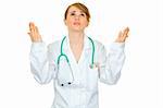 Frustrated medical doctor woman looking up and  raising her hands isolated on white