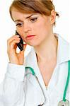 Worried medical female doctor talking on mobile phone isolated on white