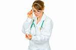 Concentrated medical female doctor in eyeglasses reading name of drug isolated on white