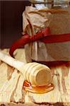 jar with honey and wooden spoon for honey on a brown background