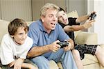 Uncle and his two nephews playing video games together.  Could also be father and sons.