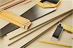 Wood working tools on a wooden boards background. Including saw, ruler, pencil, square.