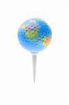 Globe with jigsaw puzzle and dimples texture on golf tee isolated on white