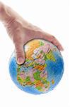 Hand gripping globe showing Africa, Europe and Asia