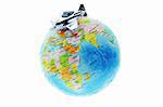 Miniature toy aircraft on top of globe
