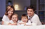 Young family with kids at night in the bedroom