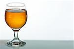 Glass of brandy on reflective surface over white background
