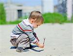 The cute boy plaing on a sand